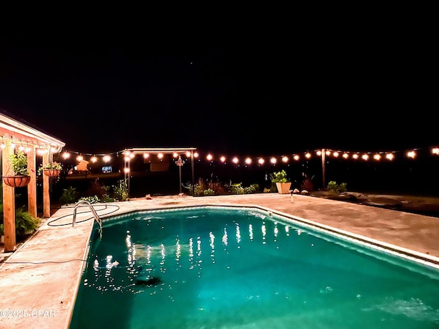 pool at twilight featuring a patio area