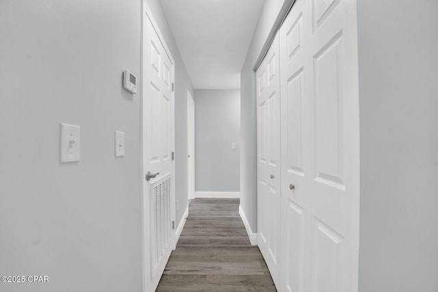 corridor with baseboards and dark wood finished floors