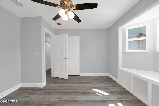 unfurnished bedroom with a closet, baseboards, and wood finished floors