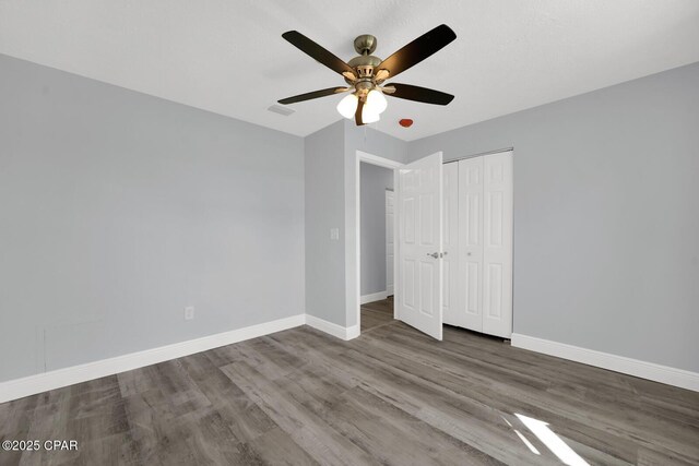 unfurnished bedroom featuring a closet, ceiling fan, and hardwood / wood-style flooring