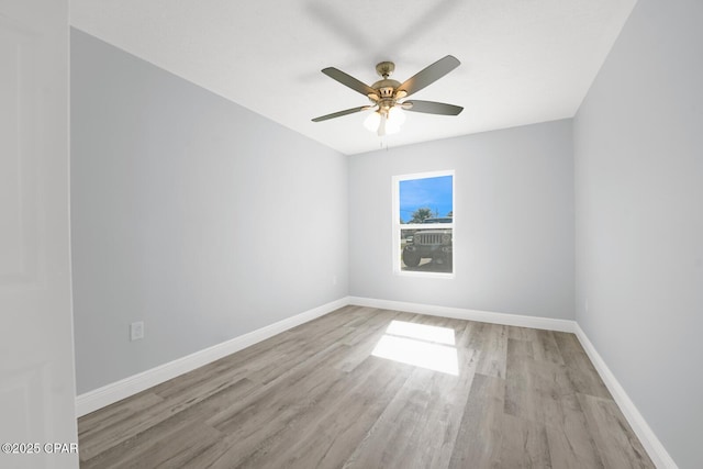 spare room with light wood finished floors, baseboards, and a ceiling fan