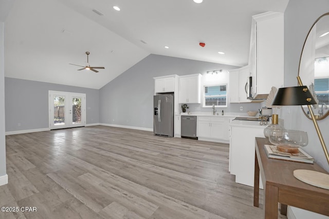 kitchen featuring white cabinets, stainless steel appliances, light countertops, french doors, and light wood-type flooring