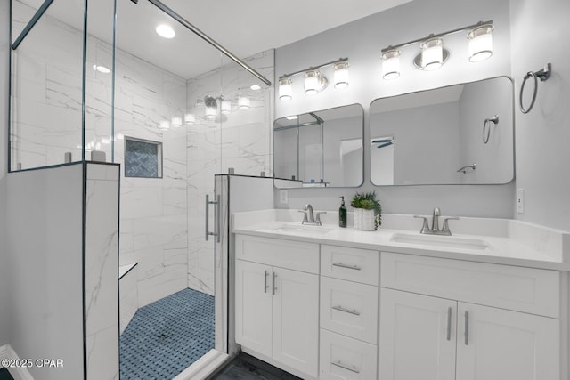 full bathroom with double vanity, a marble finish shower, and a sink