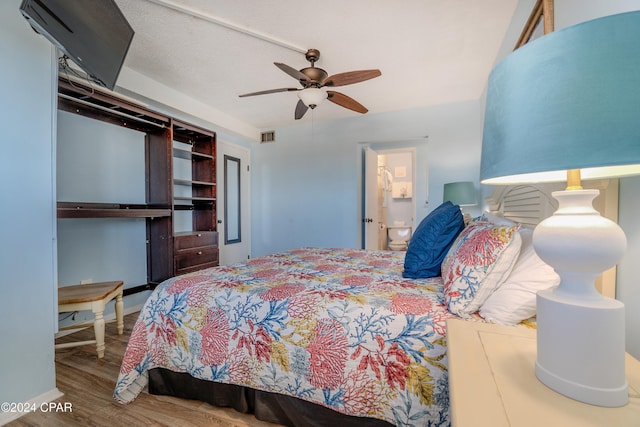 bedroom with ceiling fan, hardwood / wood-style floors, and connected bathroom