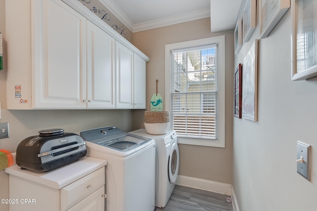 laundry area featuring independent washer and dryer, cabinets, crown molding, and light hardwood / wood-style flooring