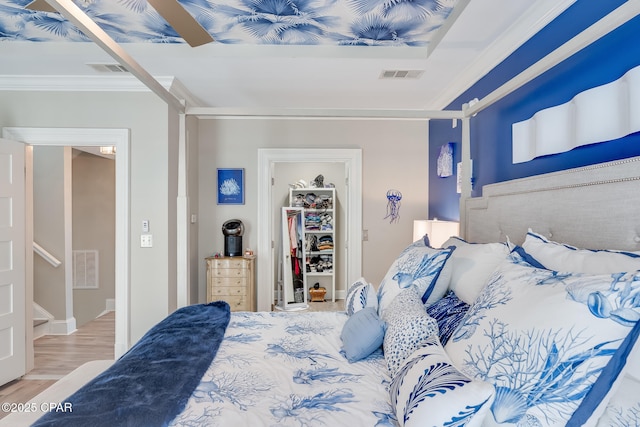 bedroom with ornamental molding, light hardwood / wood-style floors, a closet, a walk in closet, and ceiling fan