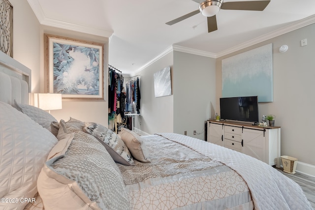 bedroom featuring ceiling fan, ornamental molding, and hardwood / wood-style flooring