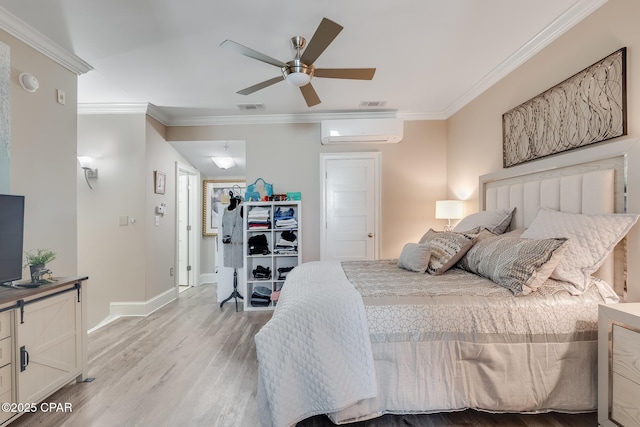 bedroom featuring ornamental molding, light wood-type flooring, a wall unit AC, and ceiling fan