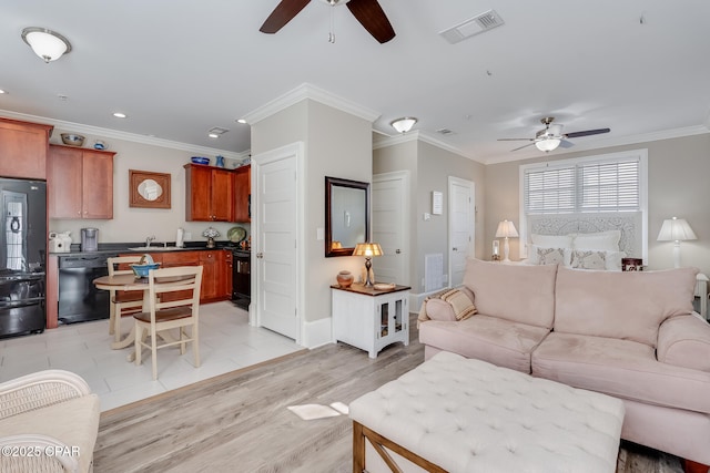 living room featuring light wood-type flooring, ceiling fan, crown molding, and sink