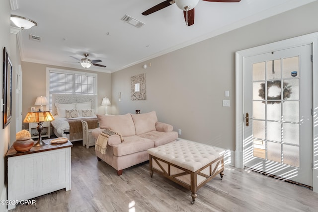 living room featuring light hardwood / wood-style floors and crown molding