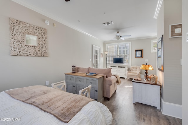 bedroom featuring ceiling fan, ornamental molding, and wood-type flooring