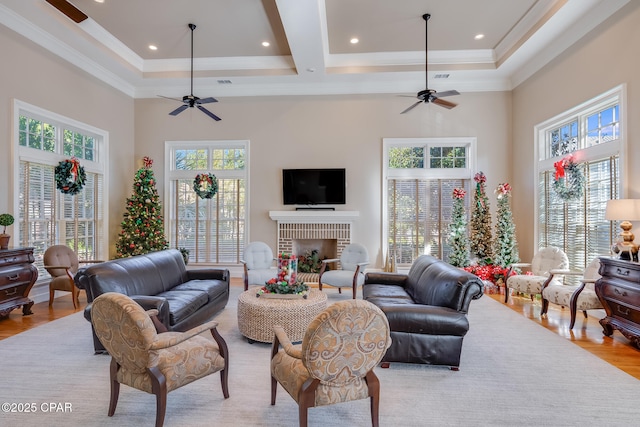 living room with a towering ceiling, a fireplace, and ceiling fan