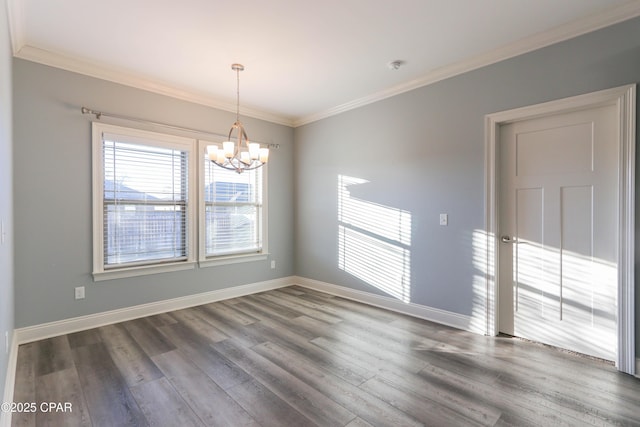 spare room featuring wood-type flooring, an inviting chandelier, and crown molding