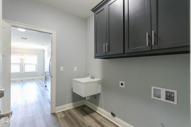 washroom featuring cabinets, dark wood-type flooring, sink, hookup for a washing machine, and hookup for an electric dryer