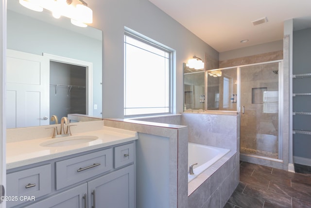 bathroom featuring vanity and separate shower and tub