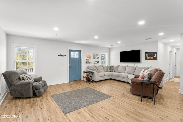 living room with plenty of natural light and light hardwood / wood-style flooring