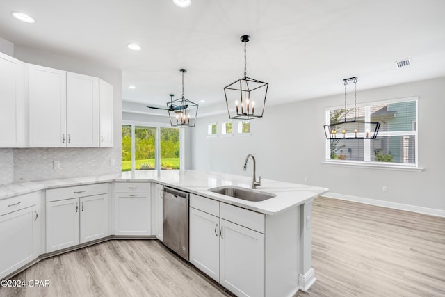 kitchen featuring white cabinetry, dishwasher, sink, decorative light fixtures, and decorative backsplash