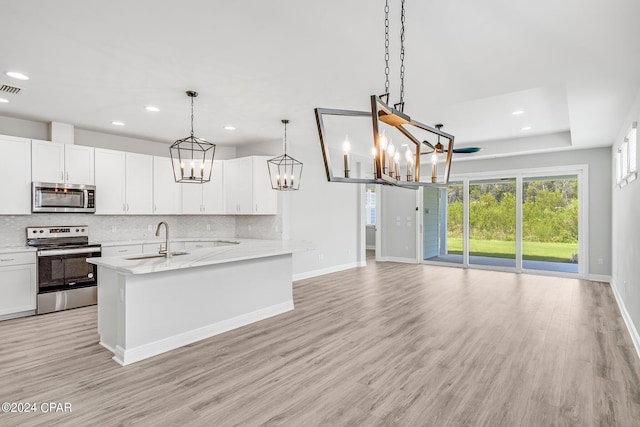 kitchen with pendant lighting, sink, white cabinets, and stainless steel appliances