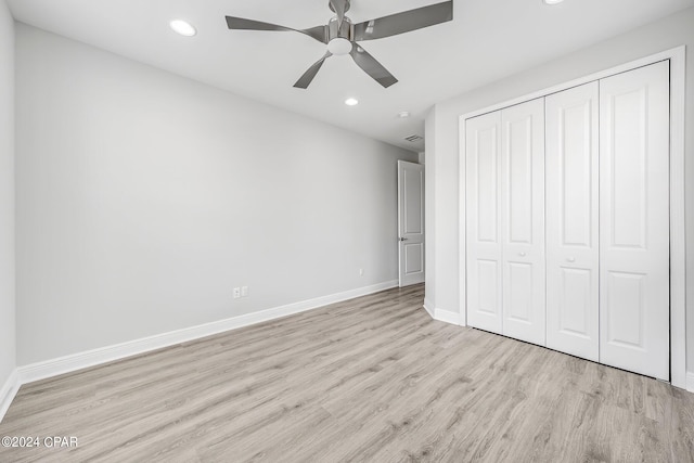 unfurnished bedroom with light hardwood / wood-style floors, a closet, and ceiling fan