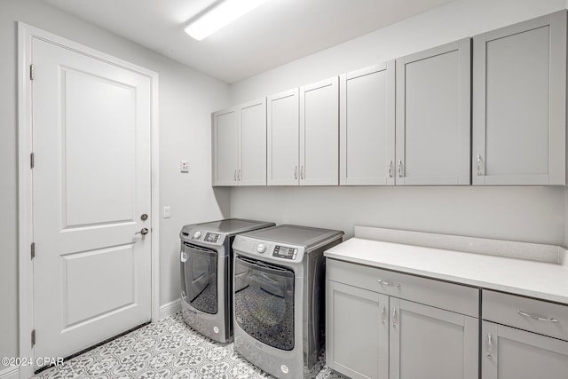 laundry room with cabinets and washer and clothes dryer