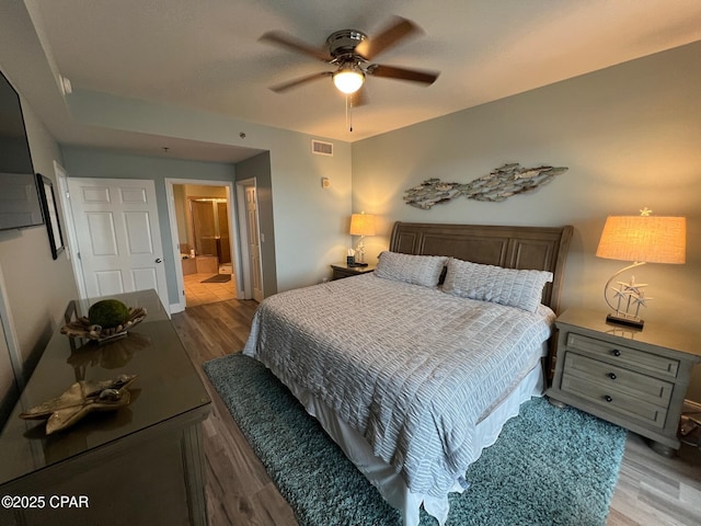 bedroom featuring connected bathroom, light hardwood / wood-style floors, and ceiling fan