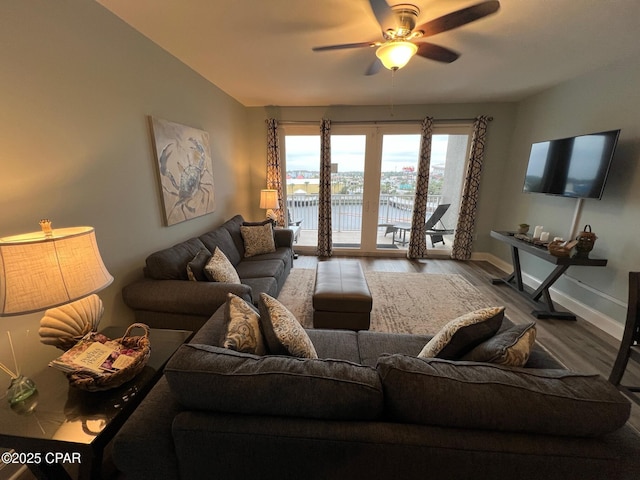 living room featuring ceiling fan, wood-type flooring, and vaulted ceiling