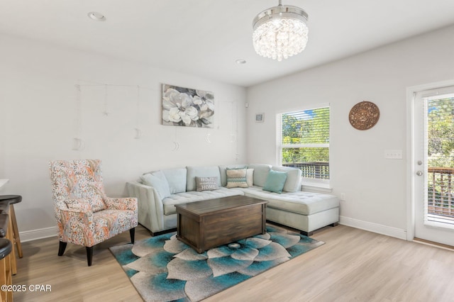 living room featuring a notable chandelier and light wood-type flooring