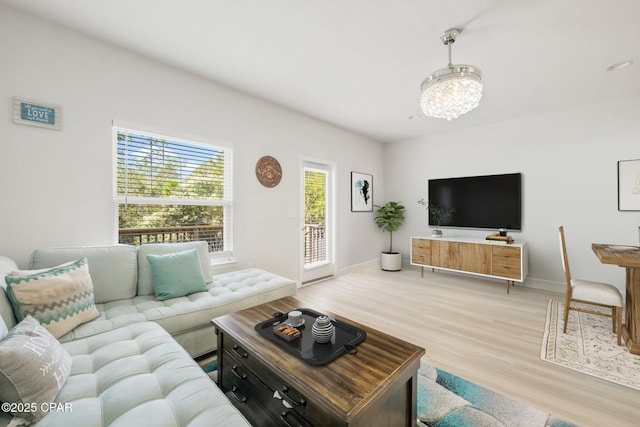 living room featuring a notable chandelier and light wood-type flooring