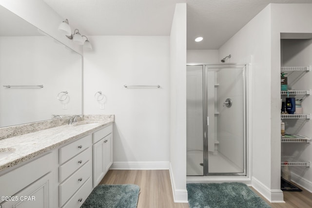 bathroom featuring vanity, hardwood / wood-style floors, and walk in shower