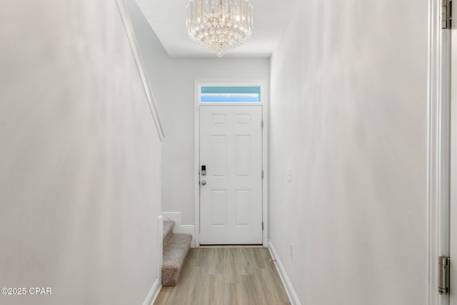 doorway featuring a notable chandelier and light hardwood / wood-style floors