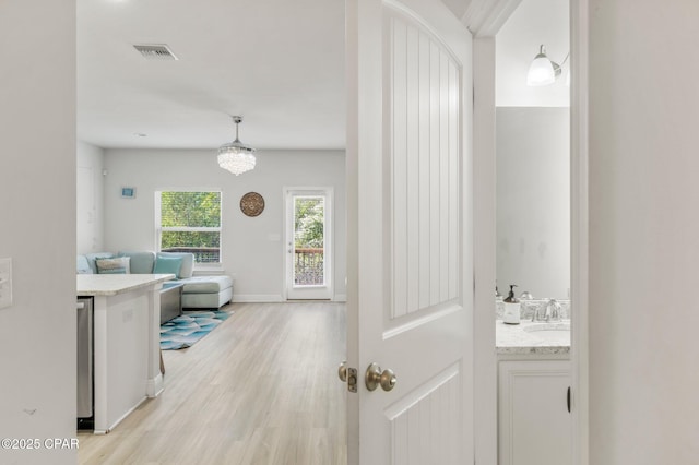 hall featuring sink and light wood-type flooring