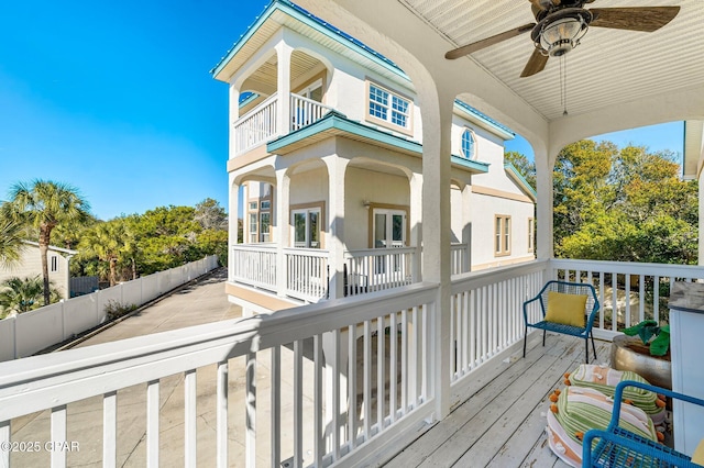 wooden terrace featuring a ceiling fan and fence