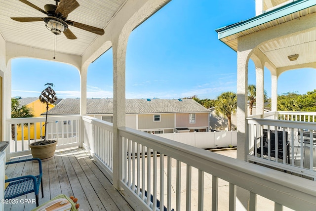 wooden deck with ceiling fan and a residential view