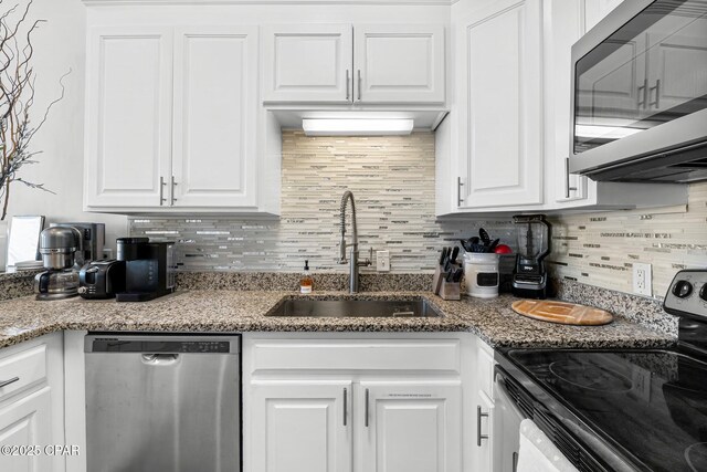 kitchen featuring white cabinetry, sink, appliances with stainless steel finishes, and tasteful backsplash