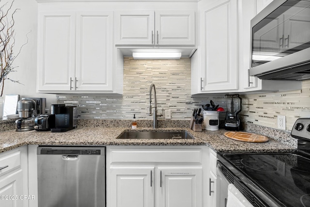 17878 Front Beach Rd Unit E2, Panama City Beach, FL 32413 - kitchen featuring decorative backsplash, white cabinets, light stone counters, appliances with stainless steel finishes, and a sink