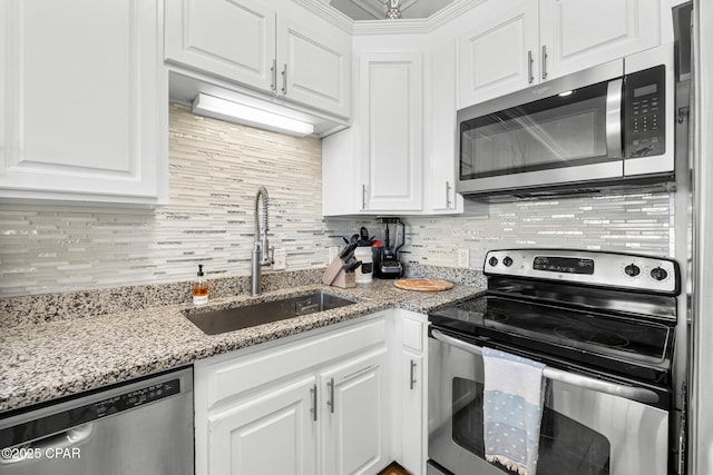 kitchen featuring white cabinets, backsplash, stainless steel appliances, and a sink