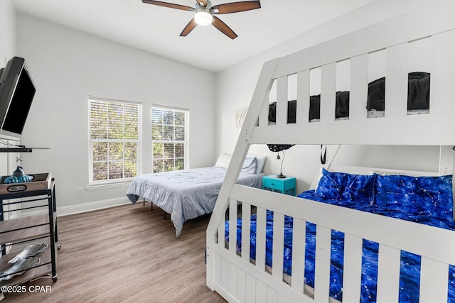 bedroom featuring a ceiling fan, baseboards, and wood finished floors