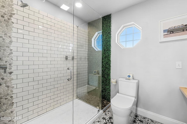 bathroom featuring a stall shower, tile patterned floors, toilet, and baseboards