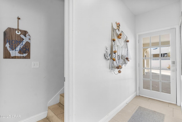 entryway with stairway, baseboards, and light tile patterned floors