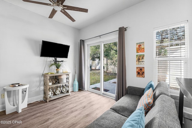 living room featuring ceiling fan, wood finished floors, and baseboards