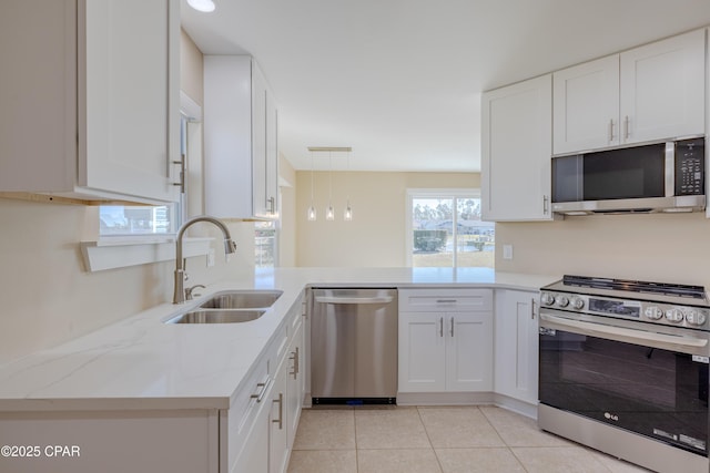 kitchen with decorative light fixtures, white cabinetry, sink, kitchen peninsula, and stainless steel appliances