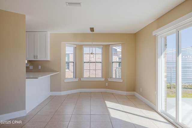 unfurnished dining area with light tile patterned floors and a wealth of natural light