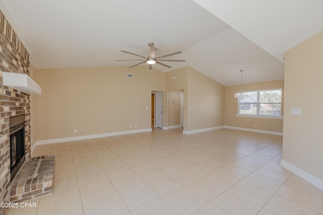 unfurnished living room with light tile patterned flooring, lofted ceiling, ceiling fan with notable chandelier, and a brick fireplace