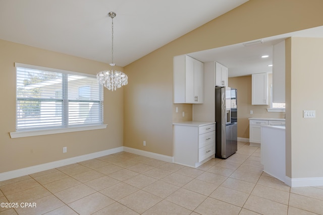 kitchen featuring lofted ceiling, light tile patterned floors, white cabinets, and stainless steel refrigerator with ice dispenser