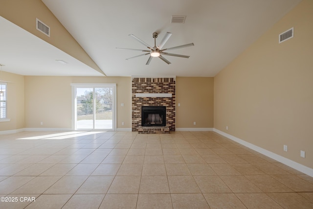 unfurnished living room with light tile patterned floors, a wealth of natural light, a fireplace, and ceiling fan