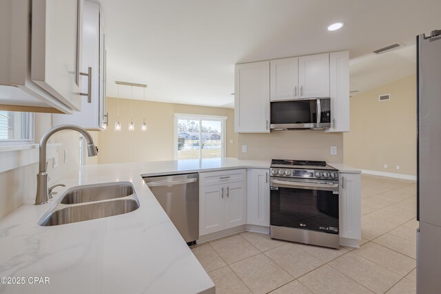 kitchen with stainless steel fridge, light tile patterned floors, white cabinetry, and sink