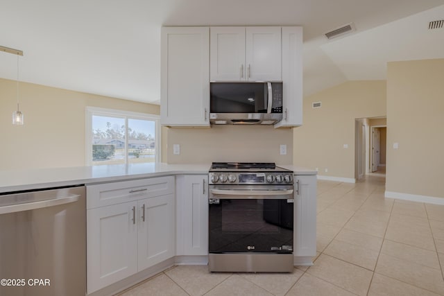 kitchen featuring white cabinetry, vaulted ceiling, hanging light fixtures, light tile patterned floors, and appliances with stainless steel finishes