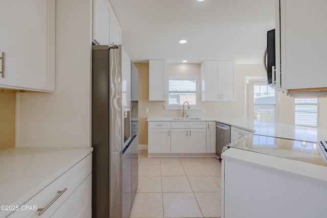 kitchen featuring white cabinetry, sink, light tile patterned floors, and stainless steel appliances