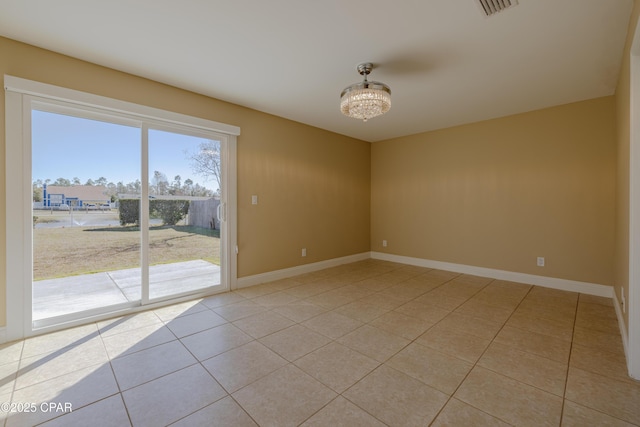 empty room featuring light tile patterned floors and a notable chandelier