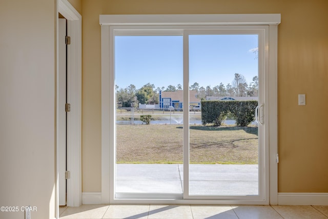 doorway featuring a water view and light tile patterned floors